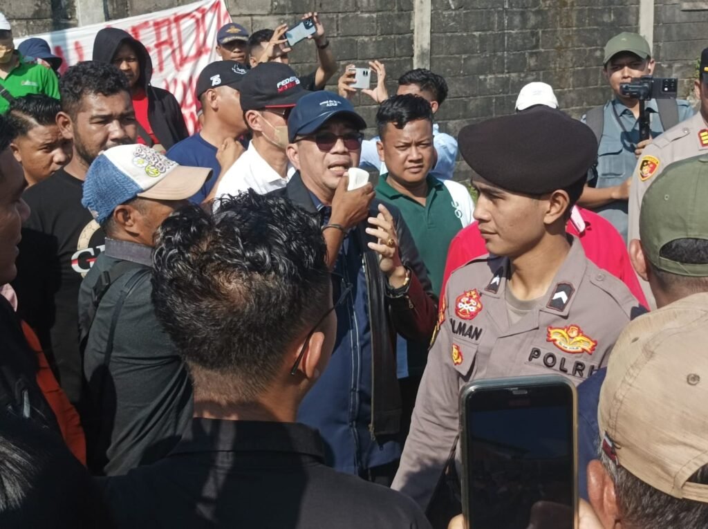 Ket. foto: Advokat Dr. Yafeti Waruwu, SH., MH. (topi dan jaket hitam) ditengah kerumunan massa Eksekusi gudang Margomulyo Surabaya pada Kamis, 4 Juni 2026.